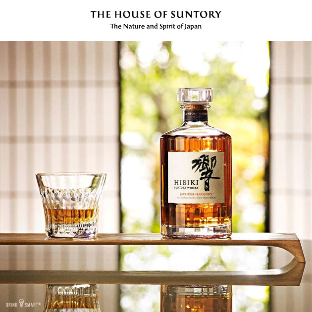 Hibiki Harmony Japanese Whisky von Suntory, Flasche neben einem Glas auf einem Holztisch